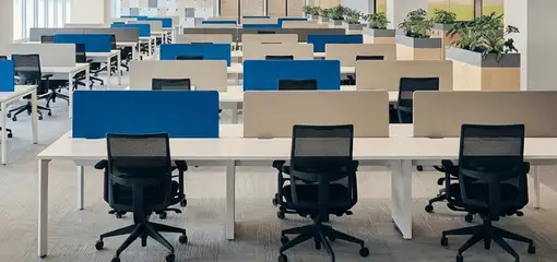 Modern open-plan office space featuring clean workstations, ergonomic chairs, and sanitized carpets provided by professional office cleaning services in Austin, TX.