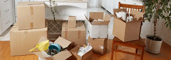 Packed moving boxes and household items in a kitchen before move-out or move-in cleaning, Austin, TX.